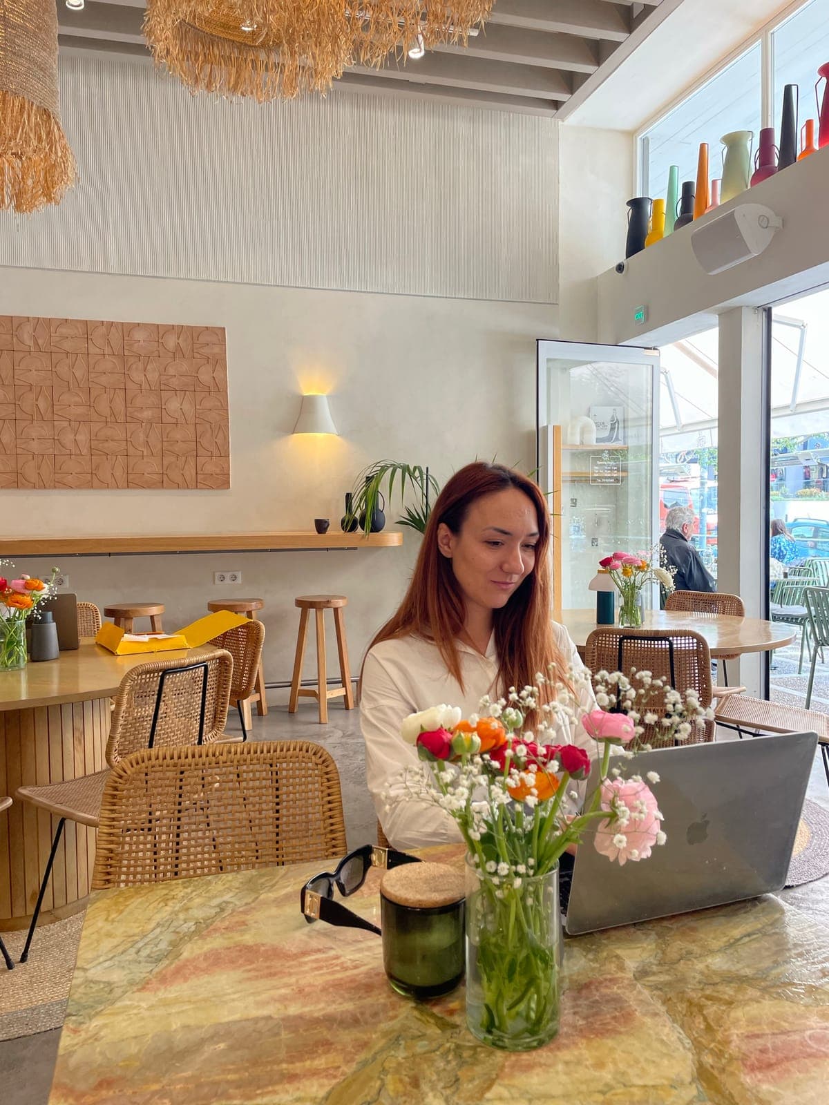 Katarina planning a trip on her laptop in a café