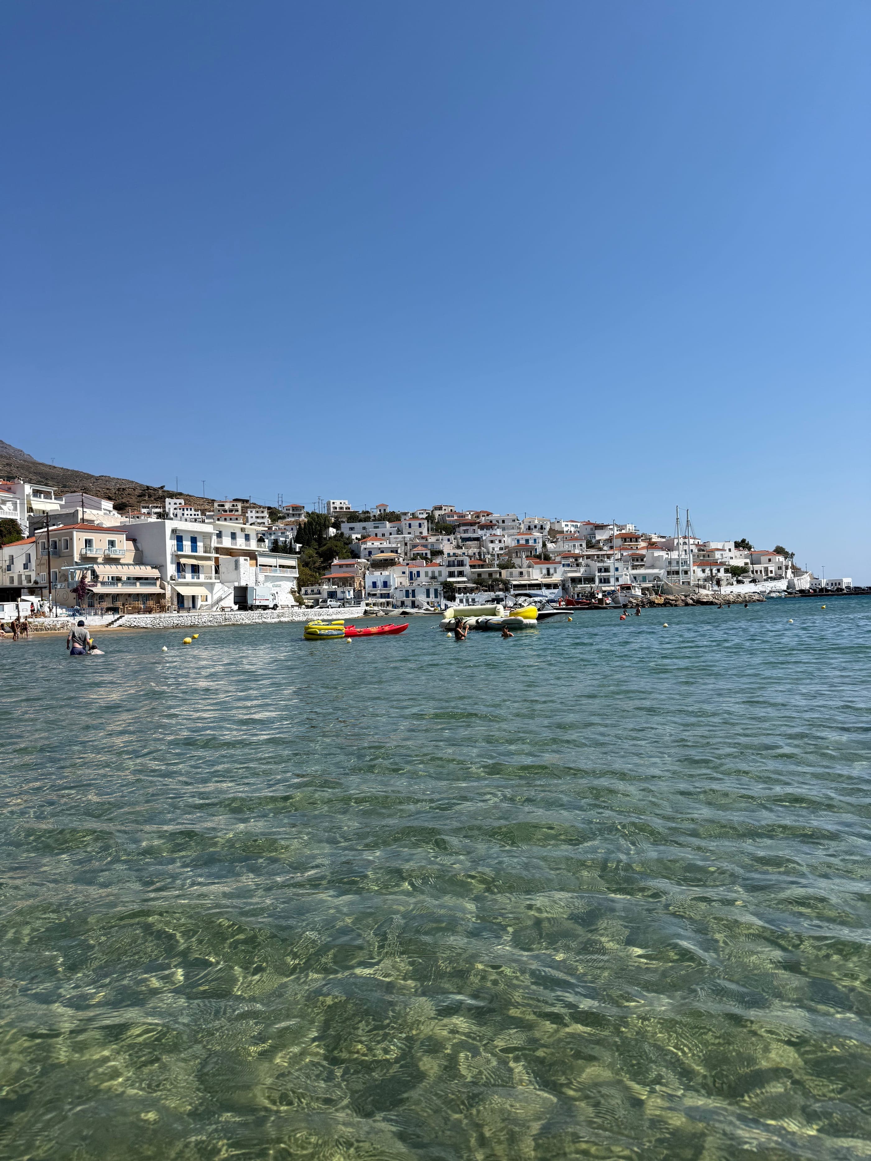 Crystal-clear water in front of the whitewashed village of Batsi, Andros