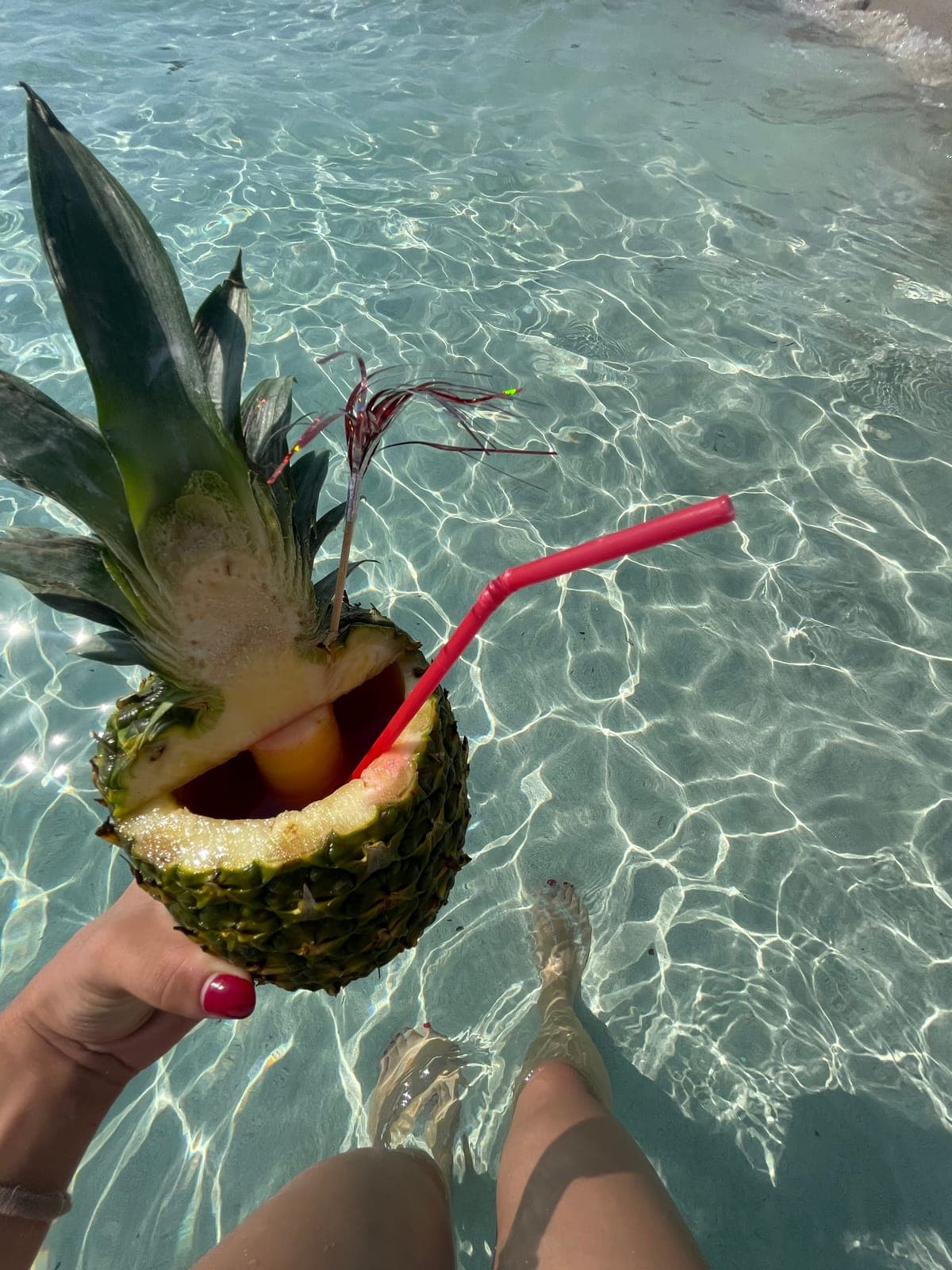 A pineapple cocktail over turquoise water