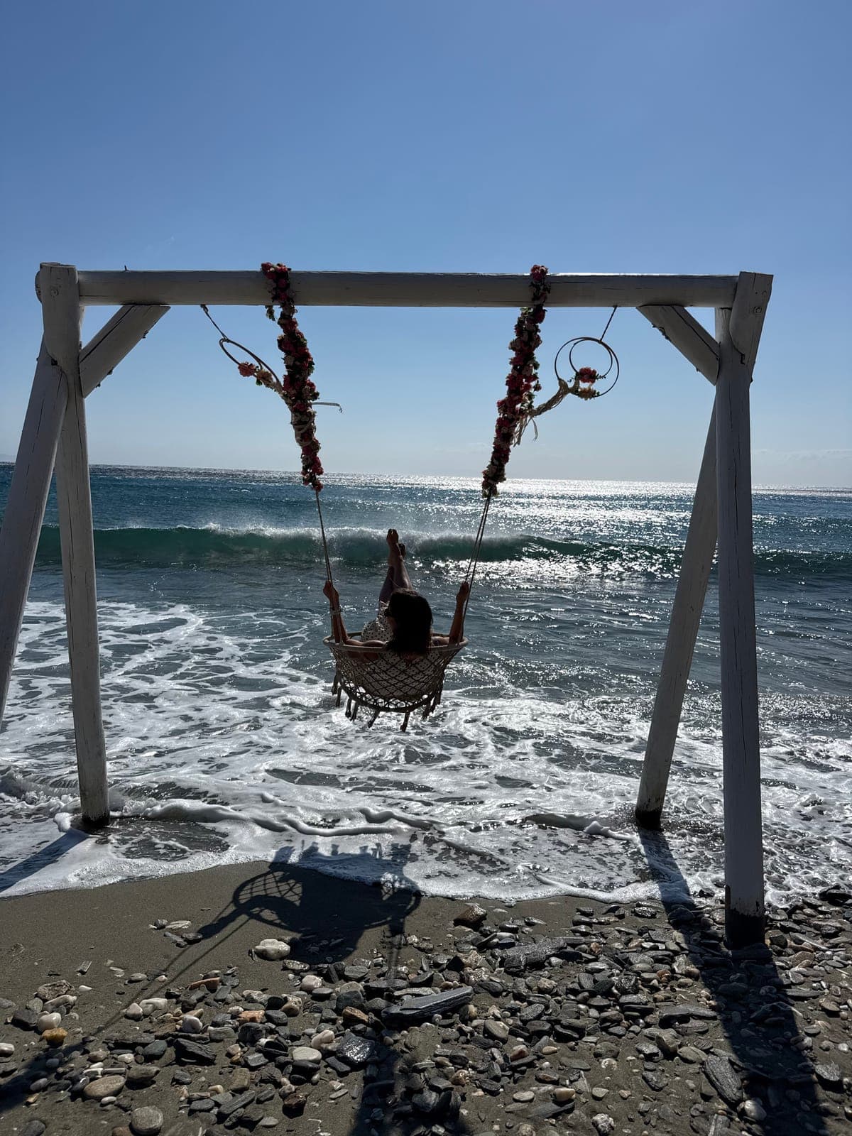 A swing on the beach facing the sea